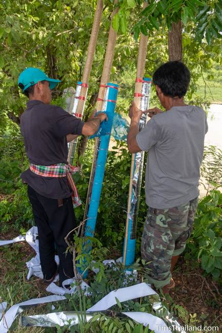 men putting silver foil on rockets