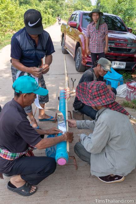 men putting silver foil on rockets