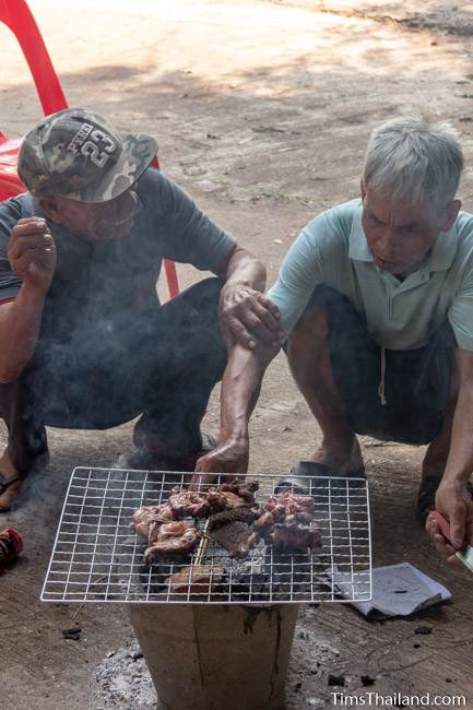 men grilling meat