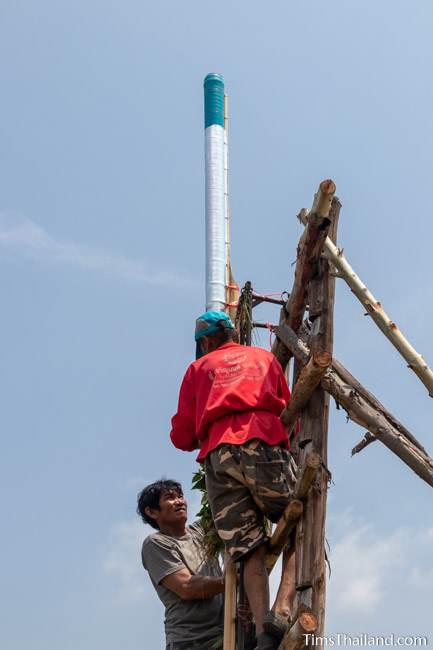 men putting rocket on launch pad