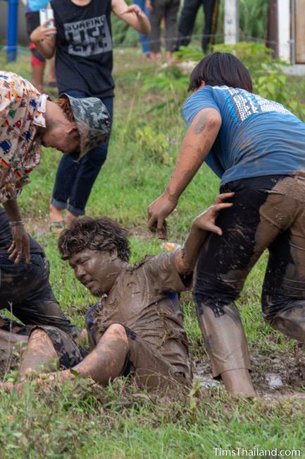 man pushing friend into mud