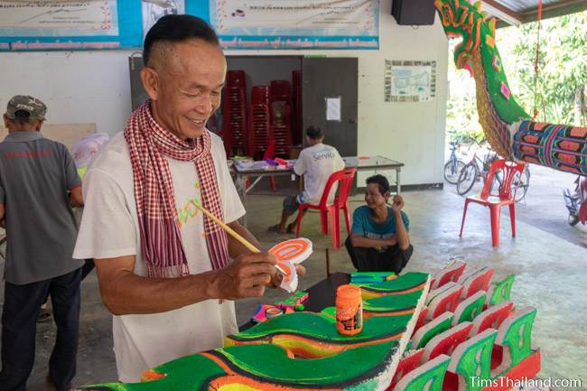 man painting piece of parade float