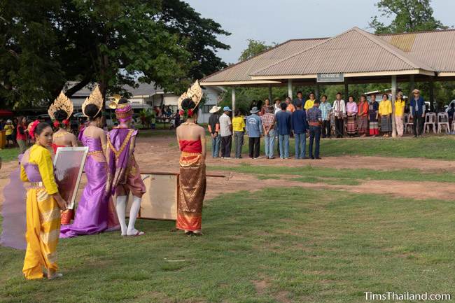 people standing before village leaders to get an award