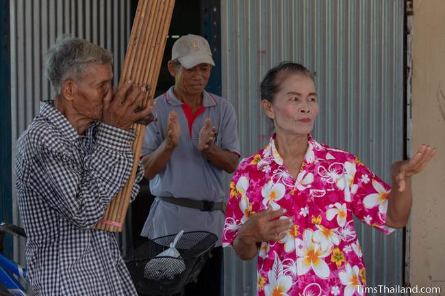 man playing the kaen and a woman dancing