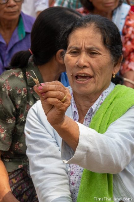 women holding chicken bone up for people to see