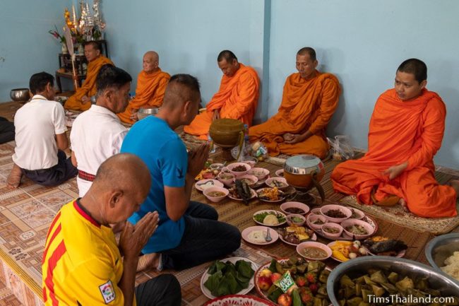 men giving food to monks