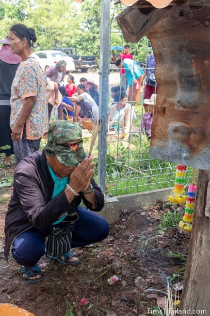 man giving incense at shrine