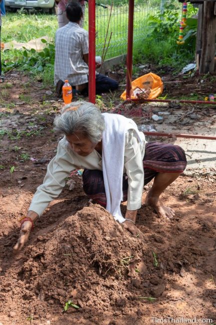 woman making dirt stupa