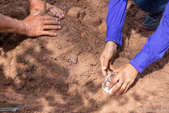 women making dirt stupa