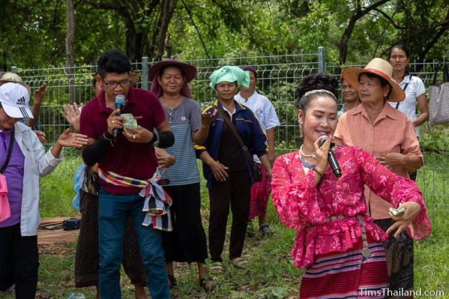 woman and man singing in front of dancers