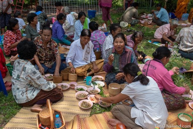 people sitting on ground and eating