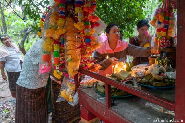 women putting food on a shrine