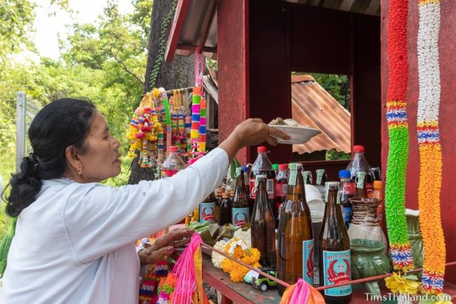 woman putting food in a shrine