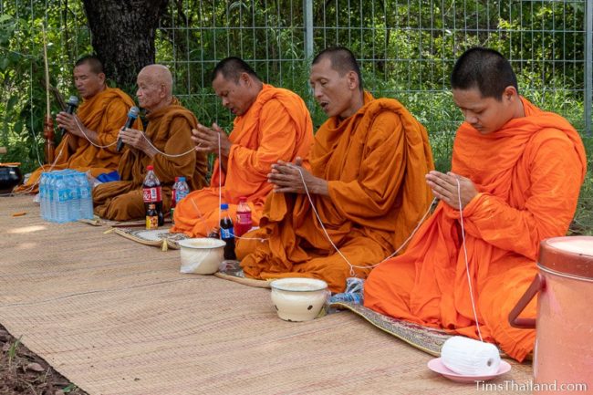 monks holding white string