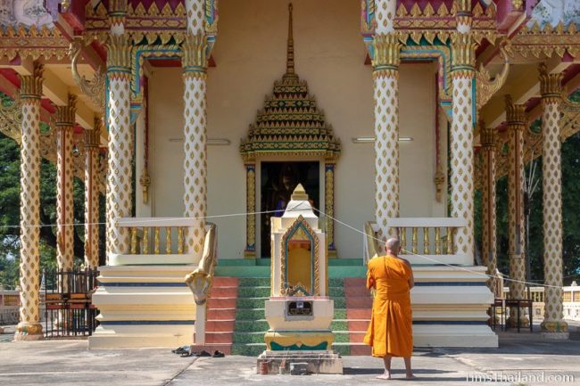 monk standing in front of the ubosot