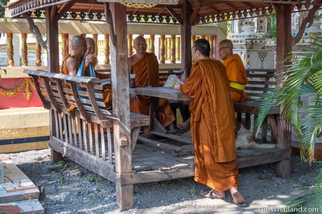 monks chatting while waiting in front of the ubosot