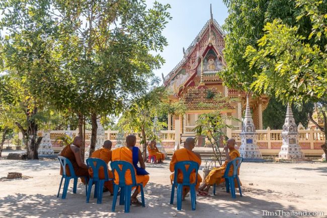 monks chatting while waiting in front of the ubosot