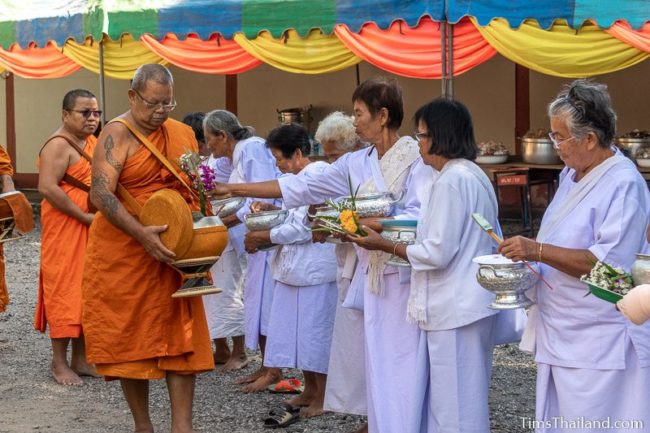 monks collecting alms from a line of people