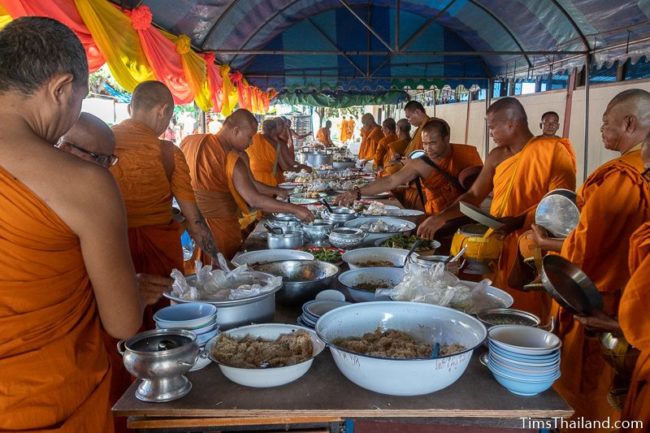 monks taking food off a table