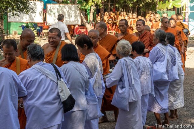 monks collecting alms from a line of people