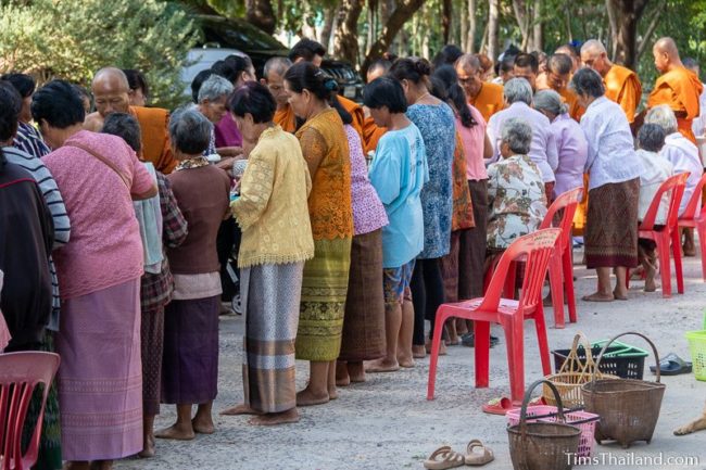 monks collecting alms from a line of people