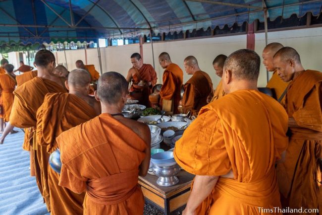 monks taking food off a table