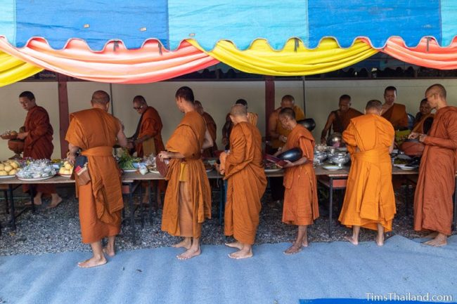 monks taking food off a table