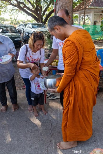 monks collecting alms from a line of people