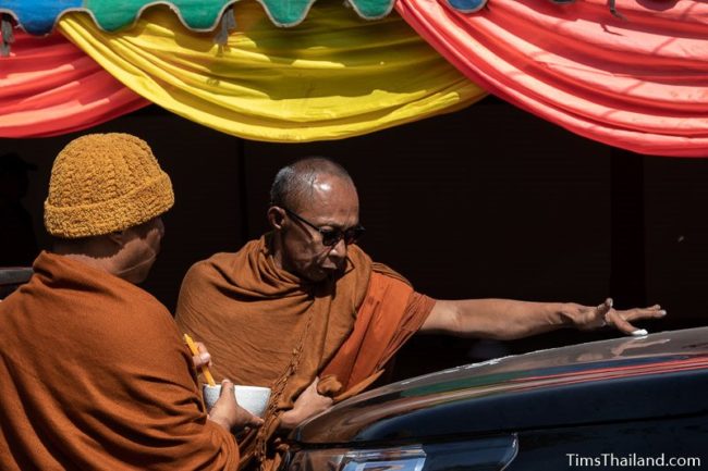 monk writing a yant on a car hood