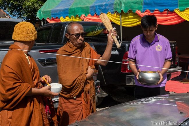 monk splashing water on a car