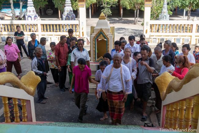 people about to be monks walking up stairs into ubosot