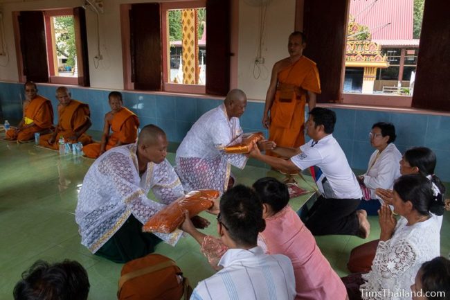 men about to become monks getting robes from their parents