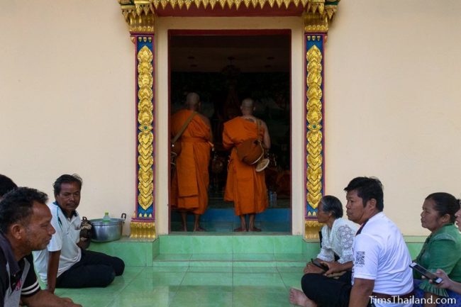 men about to become monks standing in doorway of ubusot