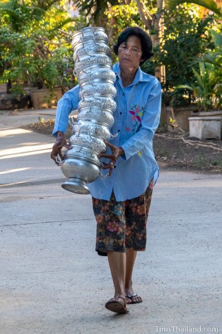 woman carrying a tall stack of rice bowls