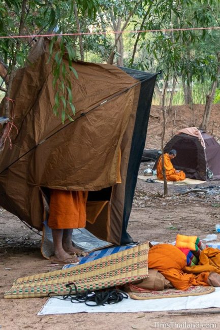 man holding up a tent to shake it out