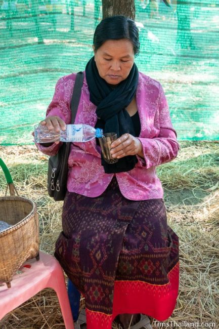 woman pouring water into a cup