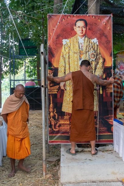 monks putting up a picture of King Rama 9