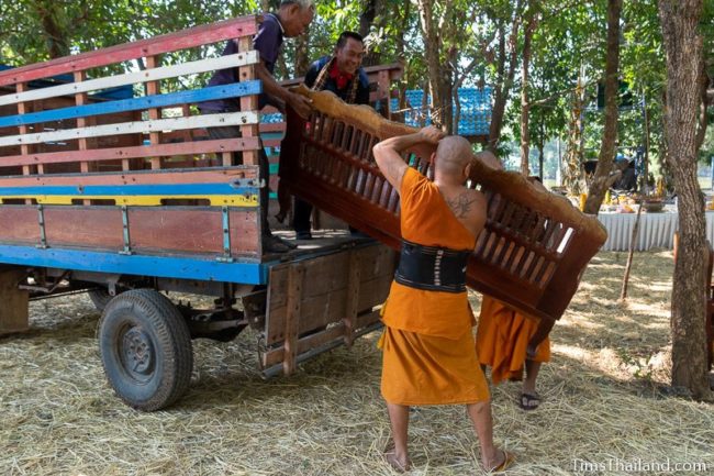 monks loading a bench onto a truck