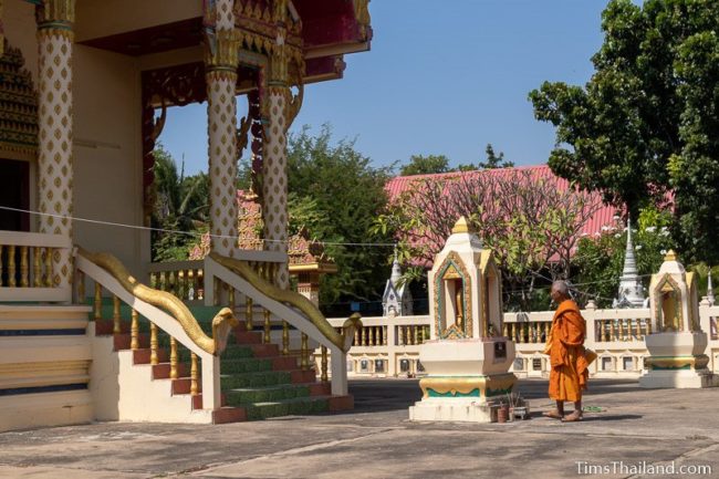 monk standing in front of ubosot