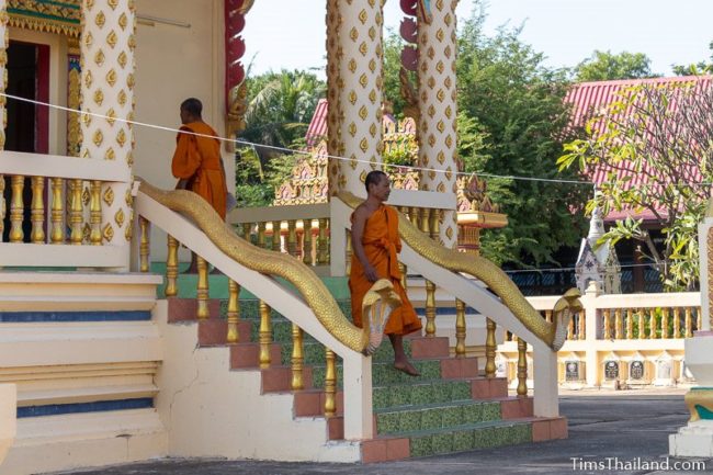 two monks walking in and out of ubosot