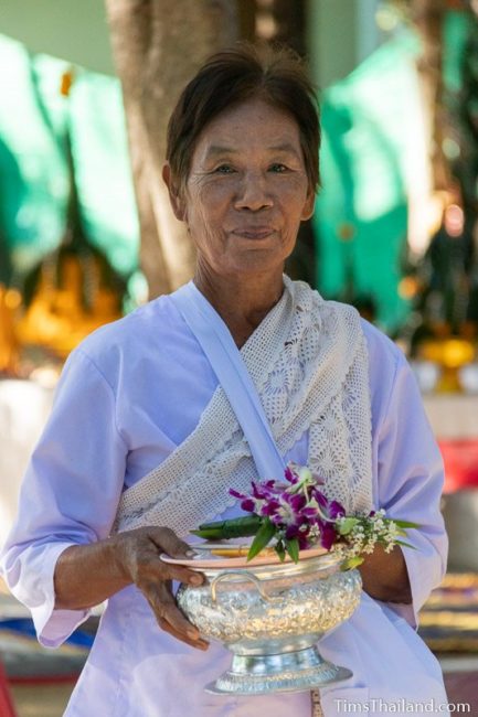 woman in white holding flowers