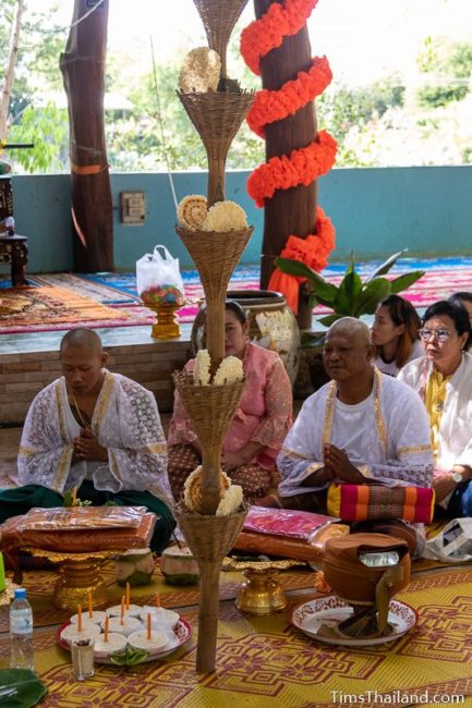 men who will become monks sitting in a ceremony