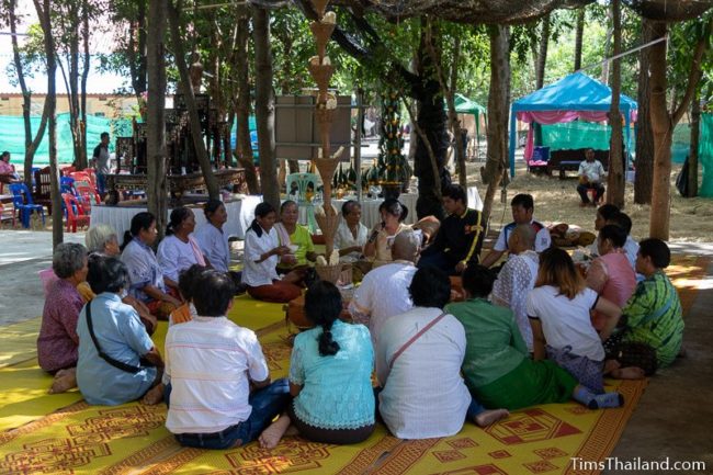 men who will become monks sitting in a ceremony