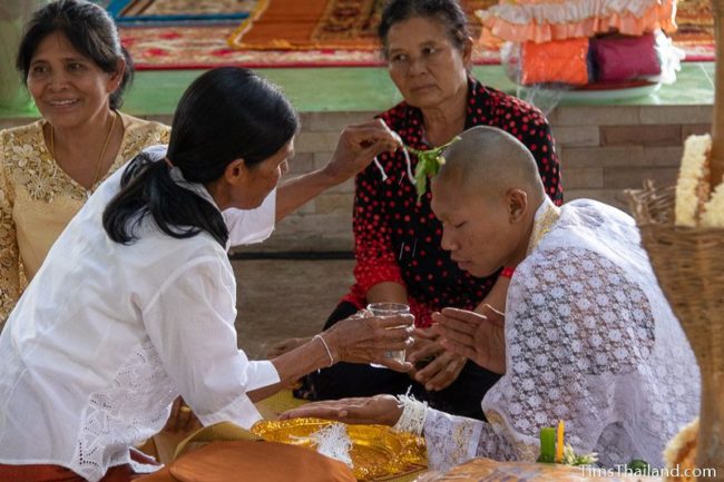 brushing leaves on head of a man who will become a monk