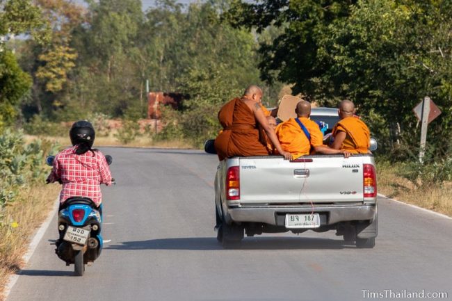 monks riding in back of pickup truck