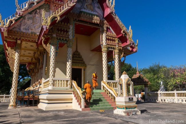 two monks walking in and out of ubosot