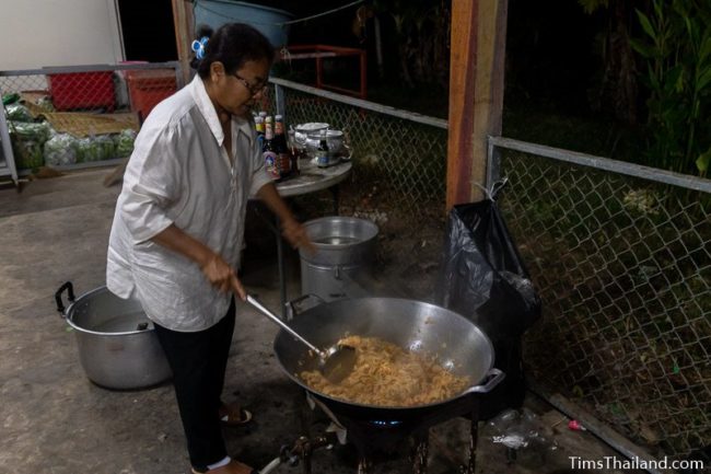 woman cooking in giant wok