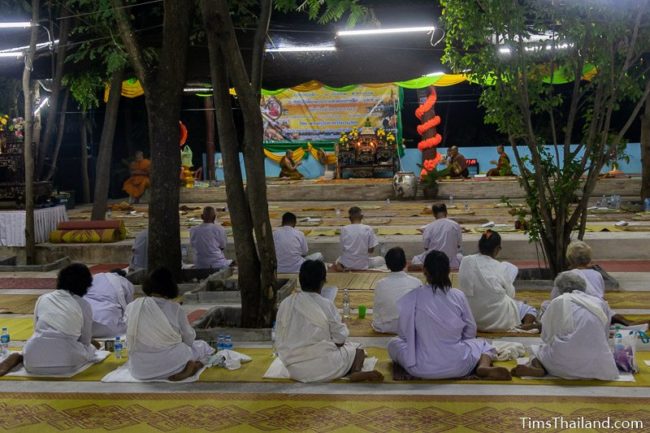 people in white meditating during the night