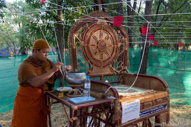 monk tying white string to a pulpit