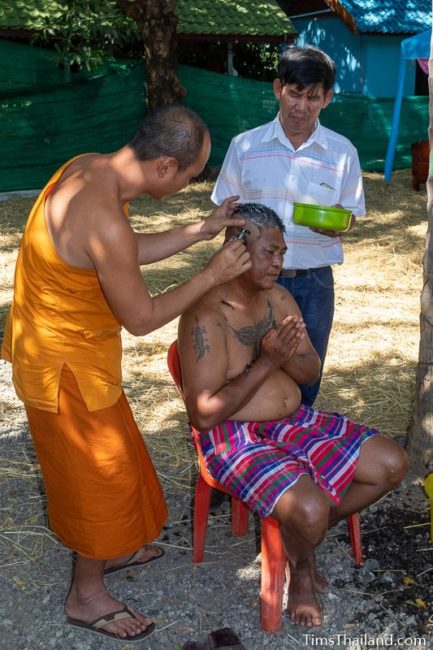 monk shaving a man's head